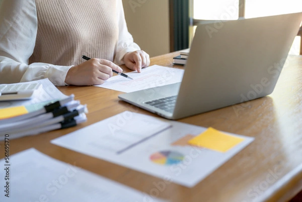 Fototapeta Businesswoman Accountant analyzing investment charts Invoice and pressing calculator buttons over documents. Accounting Bookkeeper Clerk Bank Advisor And Auditor Concept