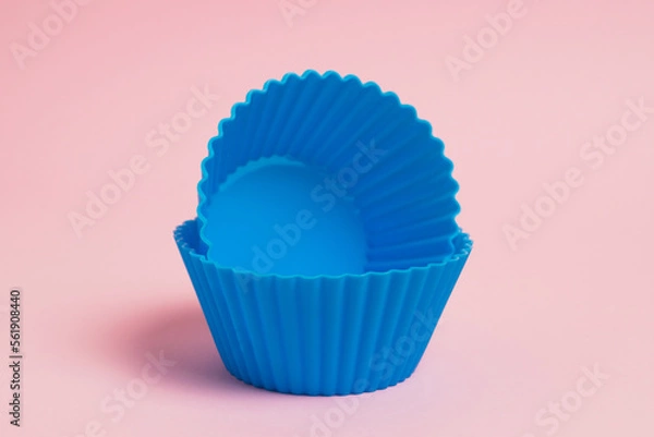 Fototapeta Blue silicone molds for cupcakes on a pink paper background
