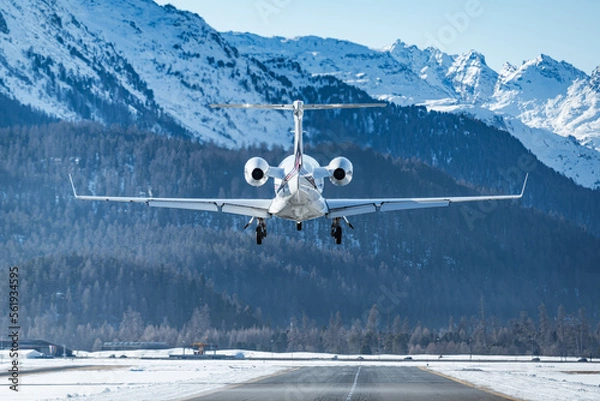 Fototapeta Luxurious business jet landing in the Swiss alps. Airplanes like this are the way to travel to the witner resort of St. Moritz for successful business people