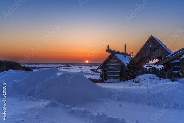 Fototapeta Rural landscape with snowdrifts and a log house on the high bank of the Irtysh, Siberia.