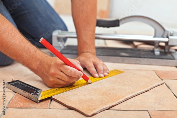 Obraz Laying ceramic floor tiles - man hands closeup