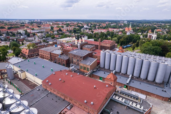 Fototapeta Brewery factory in Tychy, Poland from an aerial view on a beautiful sunny day. A giant beer brewing industry located in the Silesian Voivodeship.