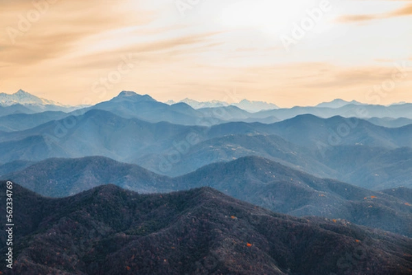 Fototapeta View from a height of 1000 m. Stunning view of the ridge of mountain peaks from a height. Mountain peaks of the Caucasus on a sunny day. A magnificent mountain range with high peaks.