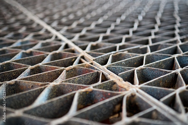 Fototapeta Metal industry steel grade sheet or floor grating with multicolored drops of paint macro closeup. Shallow depth of field diminished perspective industrial grates profiled drainage latticed flooring.