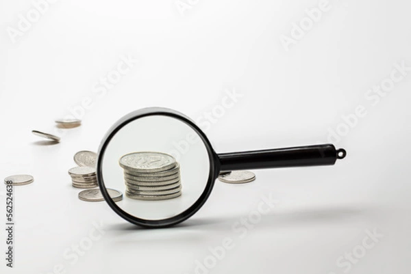 Obraz Magnifying glass with coins on gray background. Concept of banking, credit or search money.
