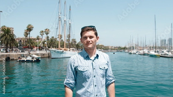 Obraz A guy in a blue shirt on the background of the yacht club.