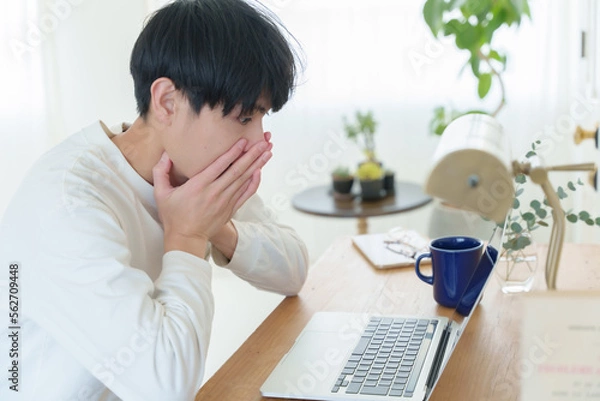 Obraz パソコンを見て驚く若い男性