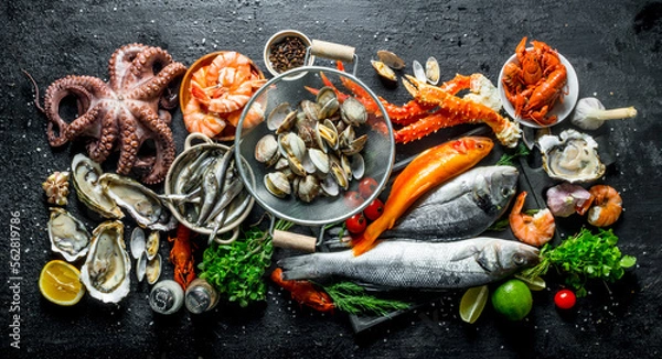 Fototapeta Variety of fresh seafood with herbs and lime.