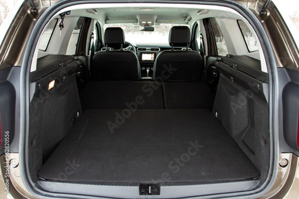 Fototapeta Huge, clean and empty car trunk in interior of compact suv. Rear view of a SUV car with open trunk