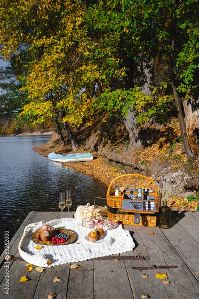 Fototapeta Picnic by the lake during autumn with vibrant foliage and a serene atmosphere