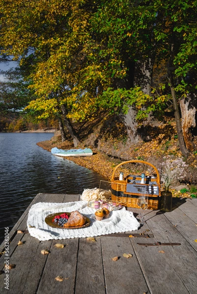 Fototapeta Picnic by the lake during autumn with vibrant foliage and a serene atmosphere