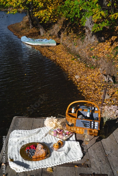 Fototapeta Picnic by the lake during autumn with vibrant foliage and a serene atmosphere