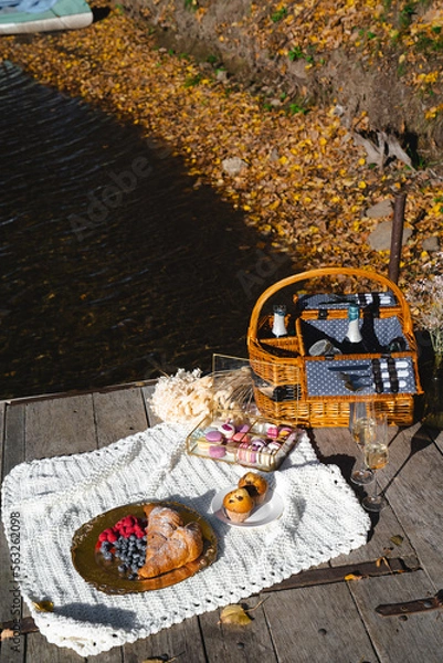 Fototapeta Picnic by the lake during autumn with vibrant foliage and a serene atmosphere