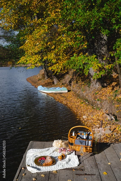 Fototapeta Picnic by the lake during autumn with vibrant foliage and a serene atmosphere