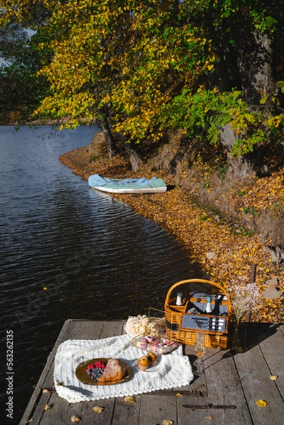 Fototapeta Picnic by the lake during autumn with vibrant foliage and a serene atmosphere