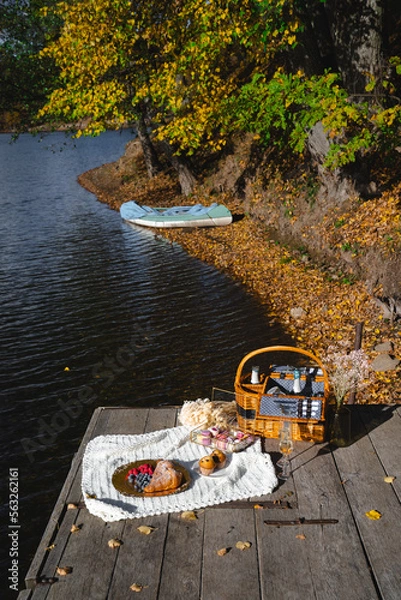 Fototapeta Picnic by the lake during autumn with vibrant foliage and a serene atmosphere