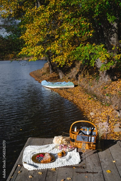 Fototapeta Picnic by the lake during autumn with vibrant foliage and a serene atmosphere