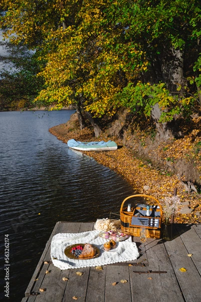 Fototapeta Picnic by the lake during autumn with vibrant foliage and a serene atmosphere