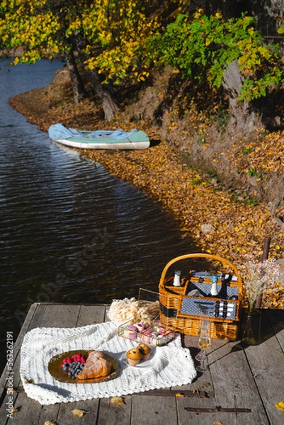 Fototapeta Picnic by the lake during autumn with vibrant foliage and a serene atmosphere