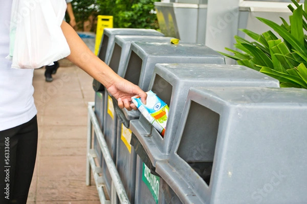 Obraz People throwing rubbish in a trash bin