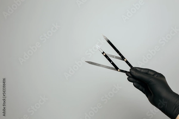 Fototapeta Beautician in gloves holding ruler for measuring brows