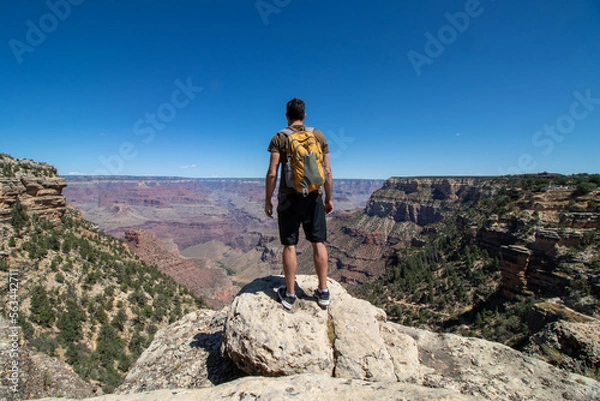 Obraz Man with yellow backpack at the edge of the Colorado canyon.