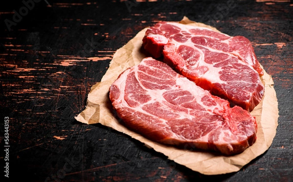 Obraz Raw pork steak on paper on the table. 
