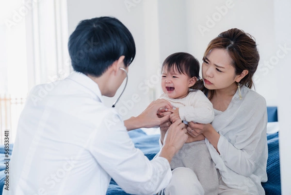 Fototapeta 家を訪問したドクターに診てもらう赤ちゃん