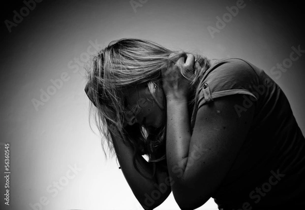 Obraz smutna kobieta siedzi sama w pustym pokoju