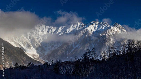 Fototapeta 雲間から顔を出す雪の穂高連峰　冬の上高地
