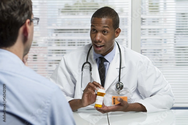 Obraz Doctor consulting patient with prescription bottle, horizontal