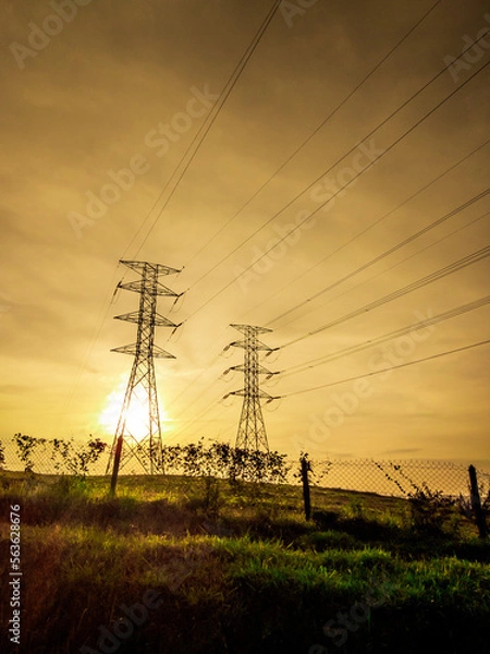Fototapeta High voltage power transmission towers Have a complex steel structure In the evening. high-voltage power lines at sunset,high voltage electric transmission tower