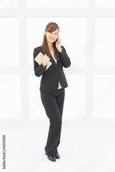 Fototapeta 携帯電話を使うビジネスウーマン