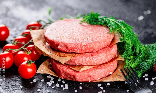 Fototapeta Raw burger on a table with greens and salt. 
