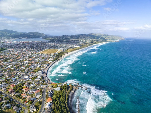 Obraz High angle aerial drone view of St Clair, a beachside suburb of Dunedin, second-largest city in the South Island of New Zealand. Dunedin city in the background. Hot water salt rock pool in foreground.