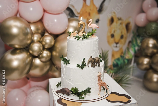 Obraz Animal themed birthday cake. Number 2 birthday candle in a cake. Two Tier Beautiful Animal Cake - flamingo, giraffe, leopard. Happy two years.