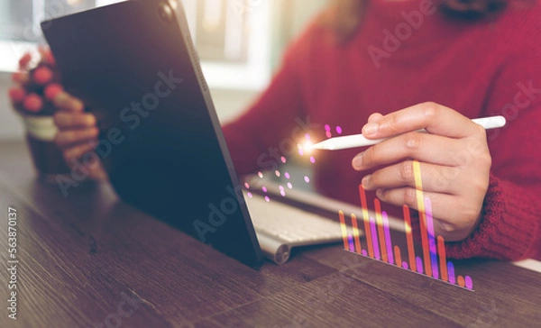 Fototapeta Accountant working with pen on graphs on tablet