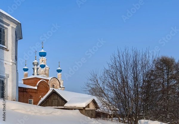 Fototapeta View of an ancient church with blue domes on a hill in Cherdyn (Northern Urals, Russia) in winter.