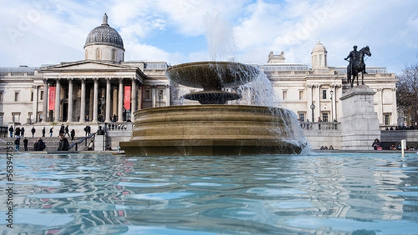 Fototapeta Fountain in Trafalgar Square London, with fountain in foreground and art galleries behind