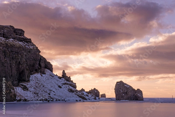 Fototapeta Early evening view as the sun is setting, of rocks on the coast of Iceland in the middle of  winter