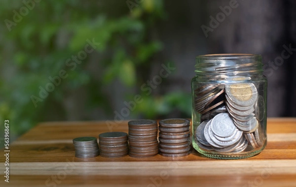 Fototapeta money saving concept, stacking coin on wooden table and natural background