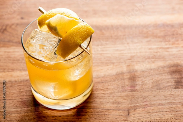 Fototapeta Whiskey sour. Classic Cocktail. Mixed drink with whiskey, lemon juice, sugar, and optionally, a dash of egg white. It is a type of sour, a mixed drink with base spirit, citrus juice, and a sweetener. 