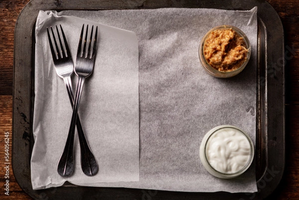 Fototapeta sauces in plates and forks on an empty paper-lined tray. Serving start. Place for text.