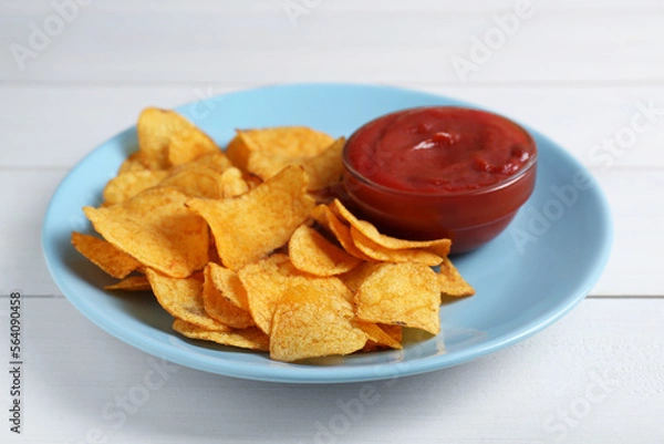 Fototapeta Delicious chips with ketchup on white wooden table