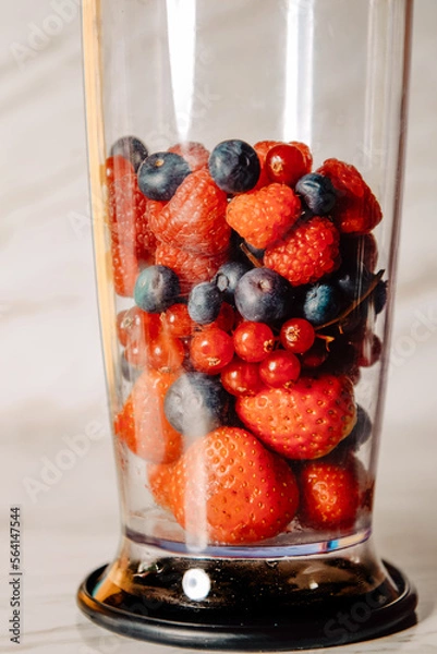 Fototapeta Fruit in a blender, mixer. Fruit cocktail and healthy food and drinks. Strawberry, raspberry, blueberry. Diet and vitamins for health, nutrition, smoothie diet.