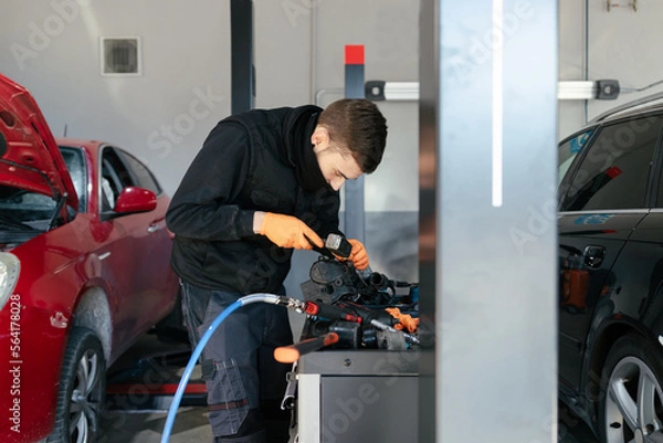 Fototapeta Car mechanic working in a garage