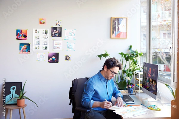 Obraz Focused man analyzing charts in creative studio