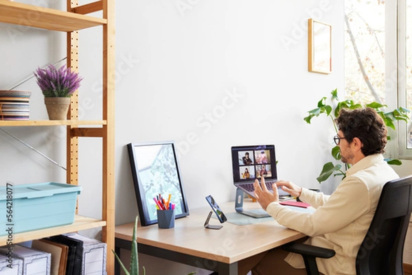 Obraz Focused designer having meeting with partners on laptop