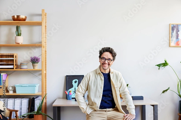 Obraz Smiling freelancer sitting in creative studio