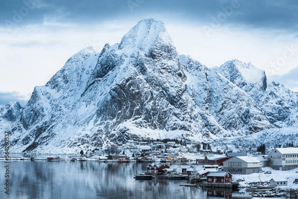 Fototapeta Morning sunrise in Reine, unbelievable view on small fishing village in Lofoten, Norway, Epic snowy mountains and red cabins with water, beautiful background picture from wild nature 
